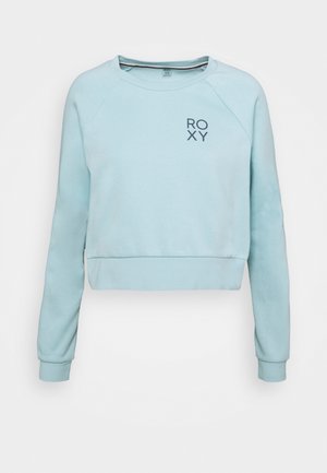 Lyseblå cropped sweatshirt med lange ærmer og lille "ROXY" logo på øverste venstre bryst.