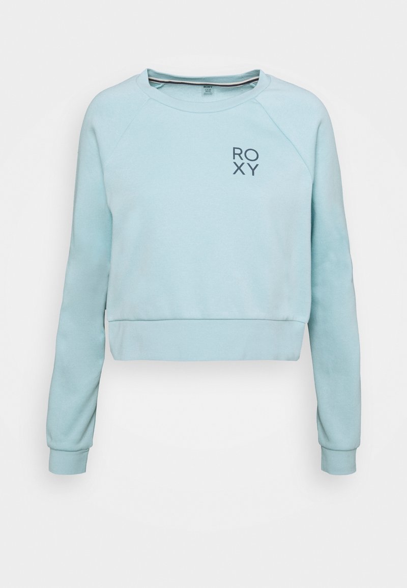 Sweat-shirt court bleu clair à manches longues avec petit logo "ROXY" sur la partie supérieure gauche de la poitrine.