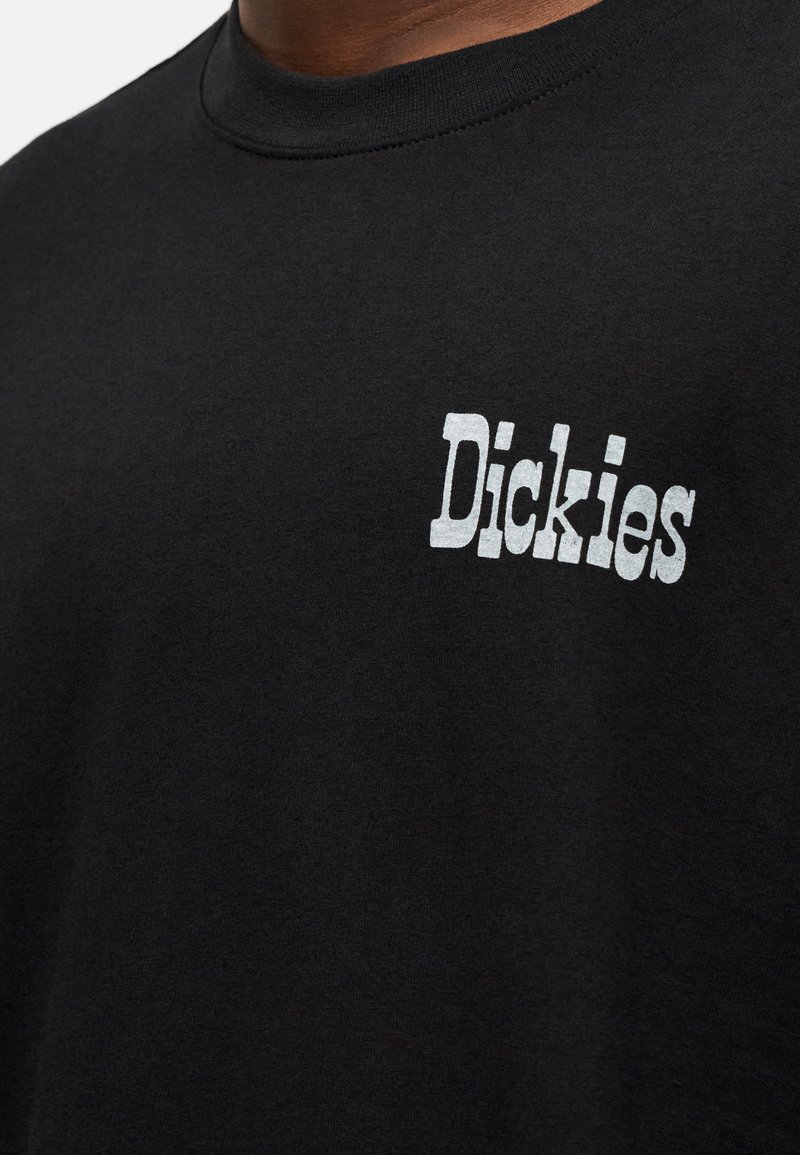 Black cotton t-shirt with a round neckline and short sleeves. Features white screen-printed "Dickies" logo on the left chest area.