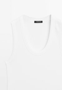 Vit, ribbad linne med rund halsringning och smala axelband; har en etikett med "Massimo Dutti" och "Tillverkad i Portugal" inuti.