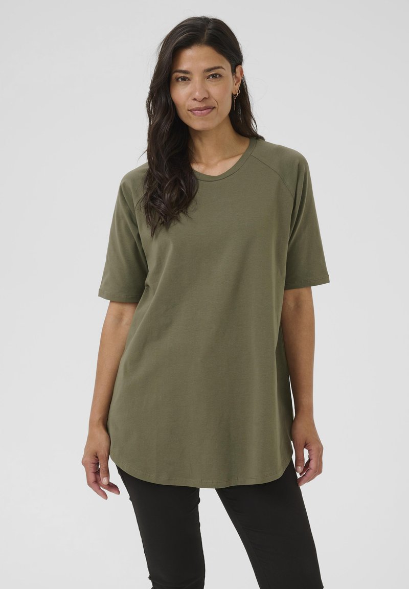Camiseta oversize de color verde olivo con mangas cortas, cuello redondo y dobladillo curvado. Fabricada en un tejido suave y transpirable.