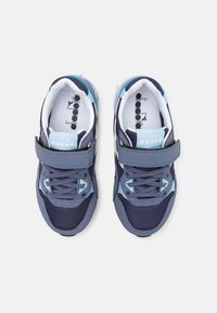 Scarpe sportive blu e blu navy realizzate in materiale mesh e sintetico, dotate di una fascia in velcro, lacci e un logo prominente sulla linguetta.