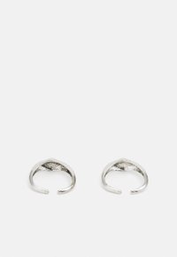 Åpne sølvringer med en glatt overflate, preget av en avsmalnende design og spisse detaljer på toppen. Minimalistiske og med tekstur på innsiden.
