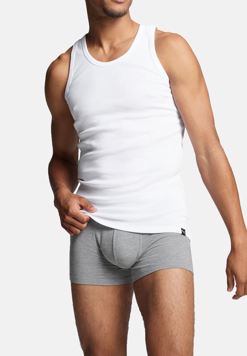 Weißes Baumwoll-Tanktop und graue Boxer-Shorts auf einer männlichen Figur. Das Tanktop hat einen Rundhalsausschnitt und die Shorts bieten einen engen Sitz.