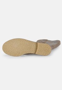 Bottines en daim avec une semelle beige texturée. La tige est d'un gris doux et discret avec un bout rond. Aucune quincaillerie ni motif visible.