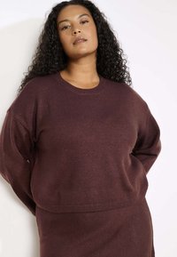 Bordoo kudumist kvarteelikaelusega, langenud õlgadega ja soonikkoes äärega. Pehme tekstuur koos peene sädelusega, loodud mugavuseks.