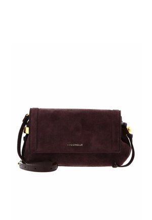 Sac bandoulière en daim bordeaux foncé avec sangle réglable et détails dorés, doté d'une fermeture à rabat et d'un petit nom de marque "Coccinelle" à l'avant.