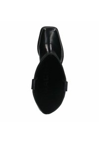 Bottine noire en cuir avec un bout pointu, une finition lisse, un matériel minimal et une silhouette épurée. L'intérieur présente un branding visible.