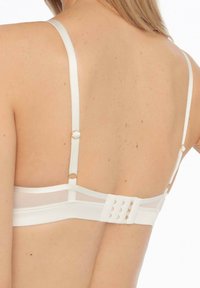 Biały stanik z cienkimi ramiączkami, siateczkowymi wstawkami oraz zapięciem na plecach na haftki z złotymi akcentami. Gładka tkanina na całej powierzchni.