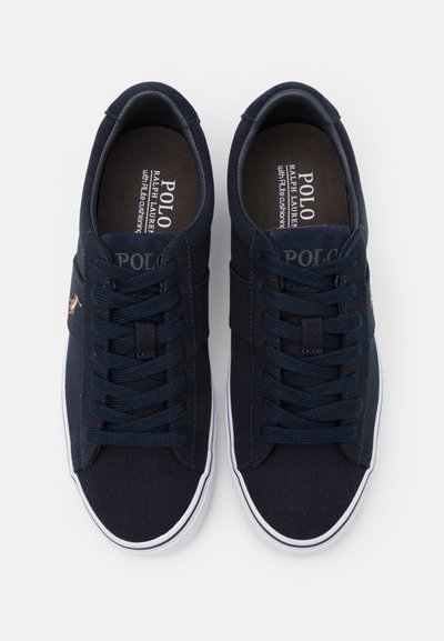 Marine lærreds sneakers med hvide gummisåler, rund tå og forhøjede syninger. Har flade snørebånd og en logo detalje på siden.
