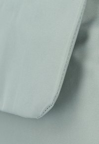 Light blue fabric with a textured weave, featuring a folded edge. The material appears durable with visible stitching along the seam.