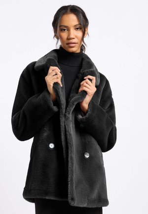 Zwarte faux fur jas met een brede kraag, dubbele knoopsluiting en lange mouwen. Zachte textuur met contrasterende blauwe knopen.