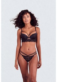 Sutien negru cu cupe structurate, prevăzut cu dantelă la margini și detalii decorative pe bretele. Tanga neagră asortată, din dantelă, cu bretele subțiri intersectate.