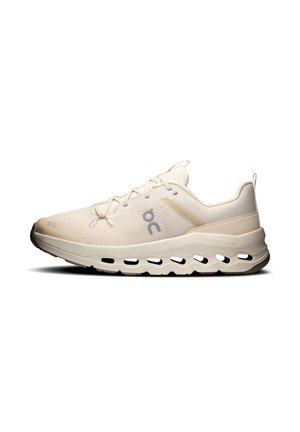Zapatilla de correr beige claro con empeine de malla, cierre de cordones, suela acolchada con diseño CloudTec y logo en el lateral.
