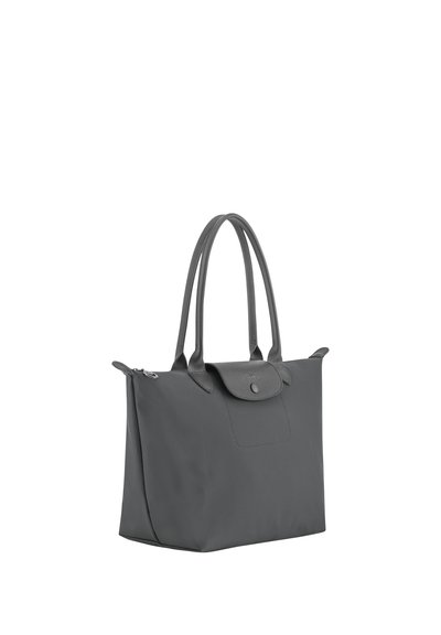 Black tote bag with double top handles, flap closure with snap button, and zipper on the top edge.