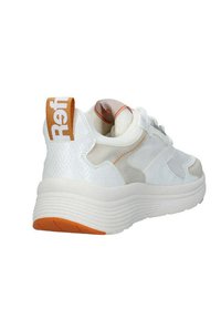 Zapatilla blanca con materiales texturizados, acentos grises y una pestaña en el talón naranja etiquetada como "Ref." Suela redondeada con estrías y un diseño de tela mixta.
