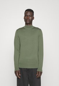Maglione verde a maniche lunghe con colletto a dolcevita in un morbido tessuto a maglia, caratterizzato da una silhouette aderente e da dettagli a coste al colletto e all'orlo.
