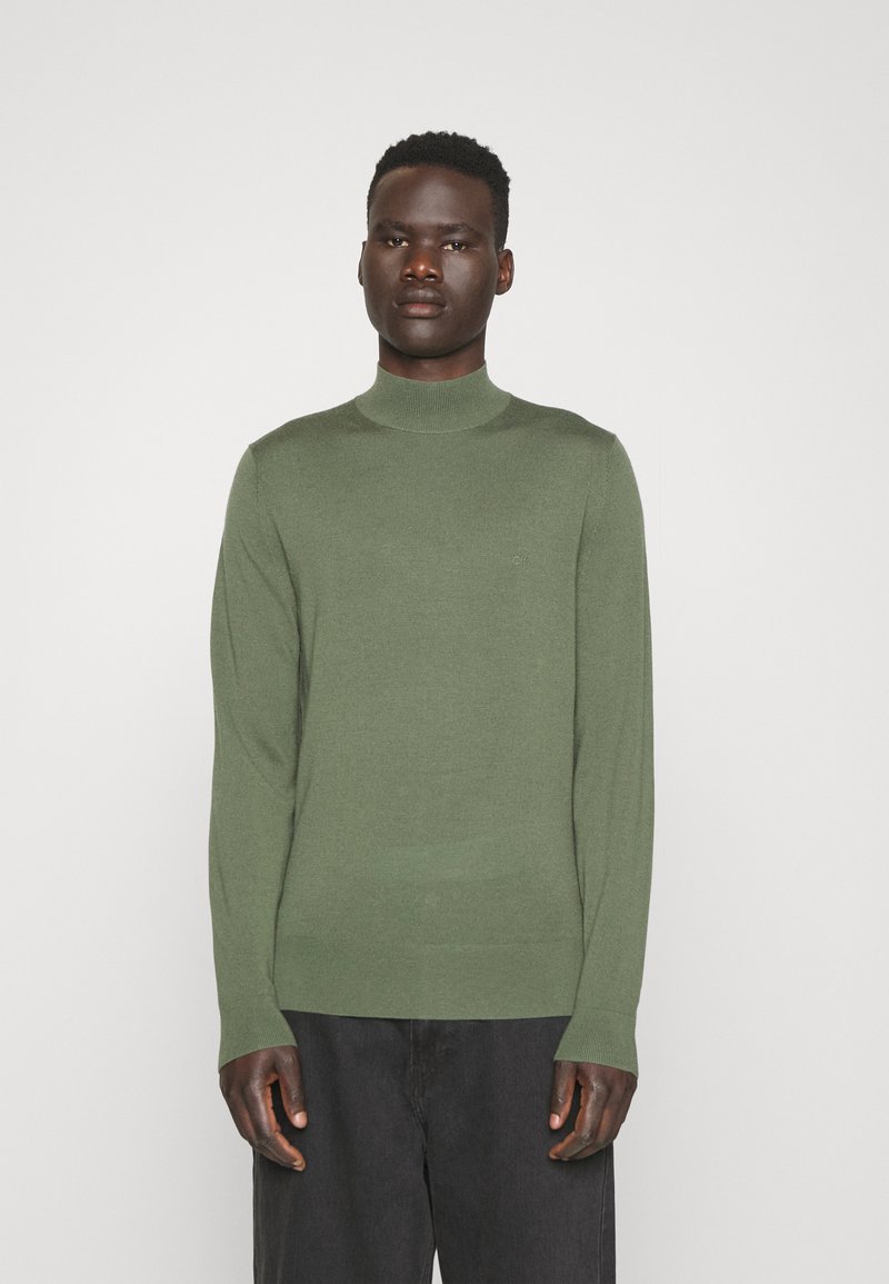 Maglione verde a maniche lunghe con colletto a dolcevita in un morbido tessuto a maglia, caratterizzato da una silhouette aderente e da dettagli a coste al colletto e all'orlo.