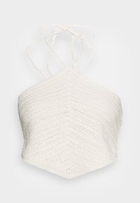 Bílý zkrácený halter top vyrobený z tkaniny s tkaným vzorem, s chevronovým vzorem a tenkými nastavitelnými ramínky uvázanými na krku.