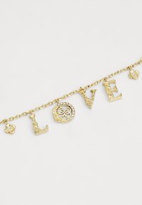 Kuldne kaelakee, millel on tähed "L," "O," "V" ja "E," keerukate tekstuuridega ja lilleaktsendiga, kaunistatud sädelevate rhinestone'idega.