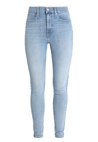 Jeans skinny de talle alto en azul claro, con botón frontal, cremallera y diseño de cinco bolsillos, exhibidos sobre un fondo blanco.