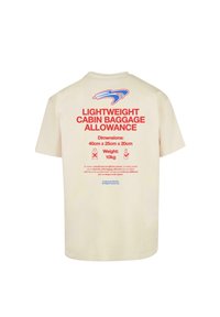 Beige T-shirt med rød tekst, der angiver "LETTERYGSACKS BAGAGEGRÆNSE" med dimensioner og vægtoplysninger. Blå logo over teksten.