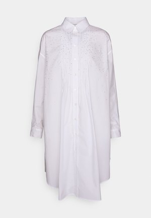 Λευκό πουκάμισο με μακριά μανίκια και κουμπί, διαθέτει πιέτες και διάσπαρτα διακοσμητικά στοιχεία στο μπροστινό μέρος. Απαλή ύφανση, χαλαρή εφαρμογή.