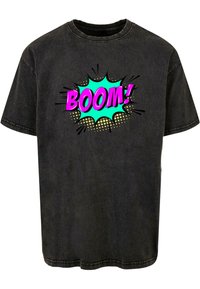 Zwart T-shirt met korte mouwen, voorzien van een stripachtige "BOOM!" grafiek in roze, turquoise en gouden stippen, met een relaxte pasvorm en ronde halslijn.