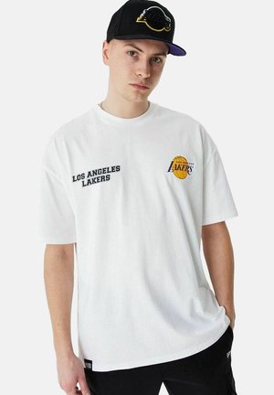 Camiseta de manga corta blanca con "LOS ANGELES LAKERS" bordado en negro y un logo de baloncesto amarillo en el pecho.