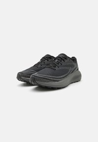 Zapatillas deportivas negras con una parte superior de malla transpirable, patrón texturizado, suela de goma resistente y un sistema de cordones prominente para un ajuste seguro.