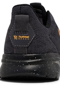 Czarne buty sportowe z teksturowaną siateczką, heksagonalnym akcentem oraz nakrapianą czarną podeszwą z logo w kolorze pomarańczowym.