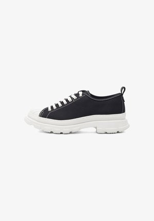 Schwarze Leinensneaker mit weißer Gummisohle, Schnürsenkeln und Stickdetails. Abgerundete Zehenkappe und hintere Schlaufe für ein einfaches Anziehen.