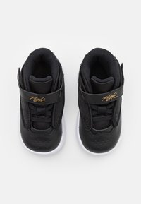 Černé tenisky s vrchní částí z síťoviny, bílou gumovou podrážkou a suchým zipem. Obsahují perforace na špičce a zlatý detail loga.