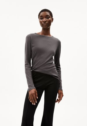 Gray long-sleeve top with a relaxed fit and round neckline, paired with black pants featuring a vertical seam. Soft texture and modern design.