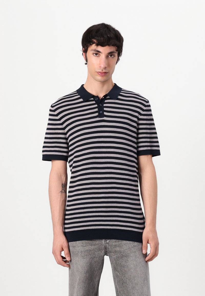 Stripet polo-shirt i marineblå og lys grå med ribbet krave, to-knaps lukning og strikket tekstur; korte ærmer og en afslappet pasform.