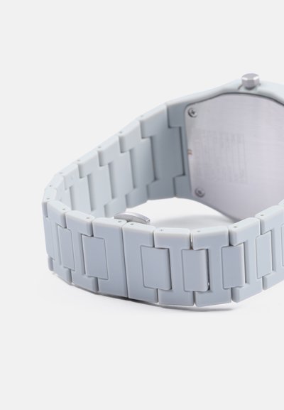 Montre en plastique gris avec un design de bracelet segmenté. Dispose d'un fond de boîtier en métal argenté et de maillons ajustables pour un meilleur ajustement.