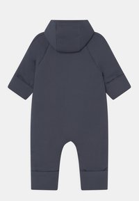 Combinaison une pièce marine avec une capuche, des manches longues et des poignets resserrés. Fabriquée en tissu lisse, présentant un design simple et minimaliste.