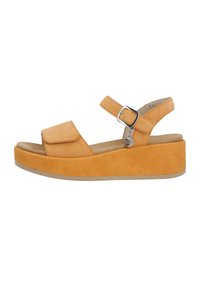 Tan suede wedge sandals with adjustable ankle strap, open toe, and a textured footbed. Features a flat, contrasting rubber sole.