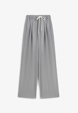 Pantalon gris clair à jambes larges en tissu lisse, doté d'une ceinture élastique avec un cordon blanc et deux poches latérales.