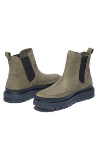 Olivgrüne Leder-Stiefeletten mit schwarzen elastischen Seiteneinsätzen und strukturierten Gummisohlen, mit runder Zehenpartie und Zuglaschen.
