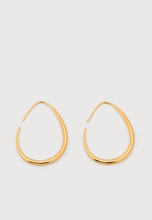 Paari läikivaid kuldseid pisara-kujulisi kõrvarõngaid, mille servad on siledad ja kergelt paksenenud, neutraalsel taustal.