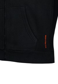 Black zip-up hoodie with front pocket and small vertical orange "U.S. Polo Assn." logo near the pocket edge.