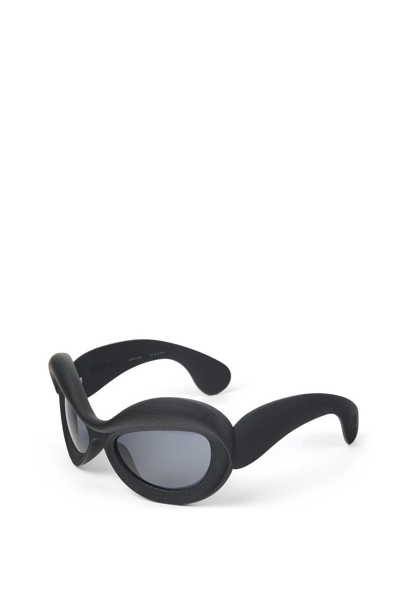 Black sunglasses with a smooth, textured finish. Oval lenses and wide, curved side arms for full coverage. Features a sleek, modern design.
