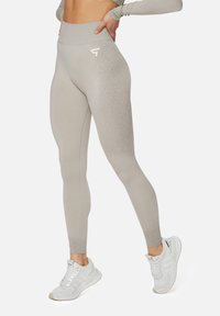 Helle graue, hoch taillierte Leggings aus dehnbarem Stoff, mit einem Farbverlaufsmuster und einem kleinen weißen Logo an der Hüfte.
