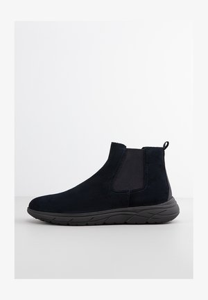 Stivaletto in pelle scamosciata nera con pannelli elastici laterali, linguetta sul retro e suola in gomma resistente, caratterizzato da un design elegante e aerodinamico.