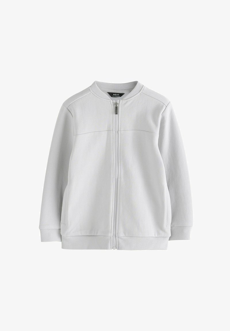 Felpa grigia chiara con zip, colletto arrotondato, tasche laterali e polsini a costine. Realizzata in tessuto testurizzato con cuciture minime.