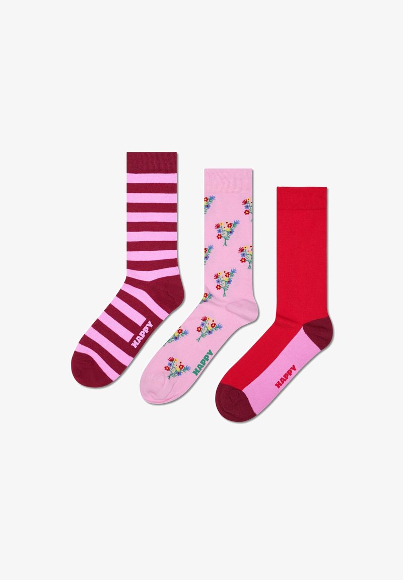 Drei Paar Socken: kastanienbraun mit rosa Streifen, rosa mit floralem Muster, einfarbig rot. Jedes Paar hat ein Logo mit der Aufschrift "HAPPY."