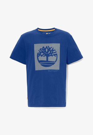 Niebieski t-shirt z krótkim rękawem i okrągłym dekoltem, z nadrukowanym stylizowanym logo drzewa w kwadracie na piersi oraz małym tekstem pod grafiką.