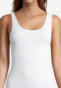 White, sleeveless tank top with a scoop neckline. Made from smooth cotton fabric, featuring a fitted design and even stitching throughout.