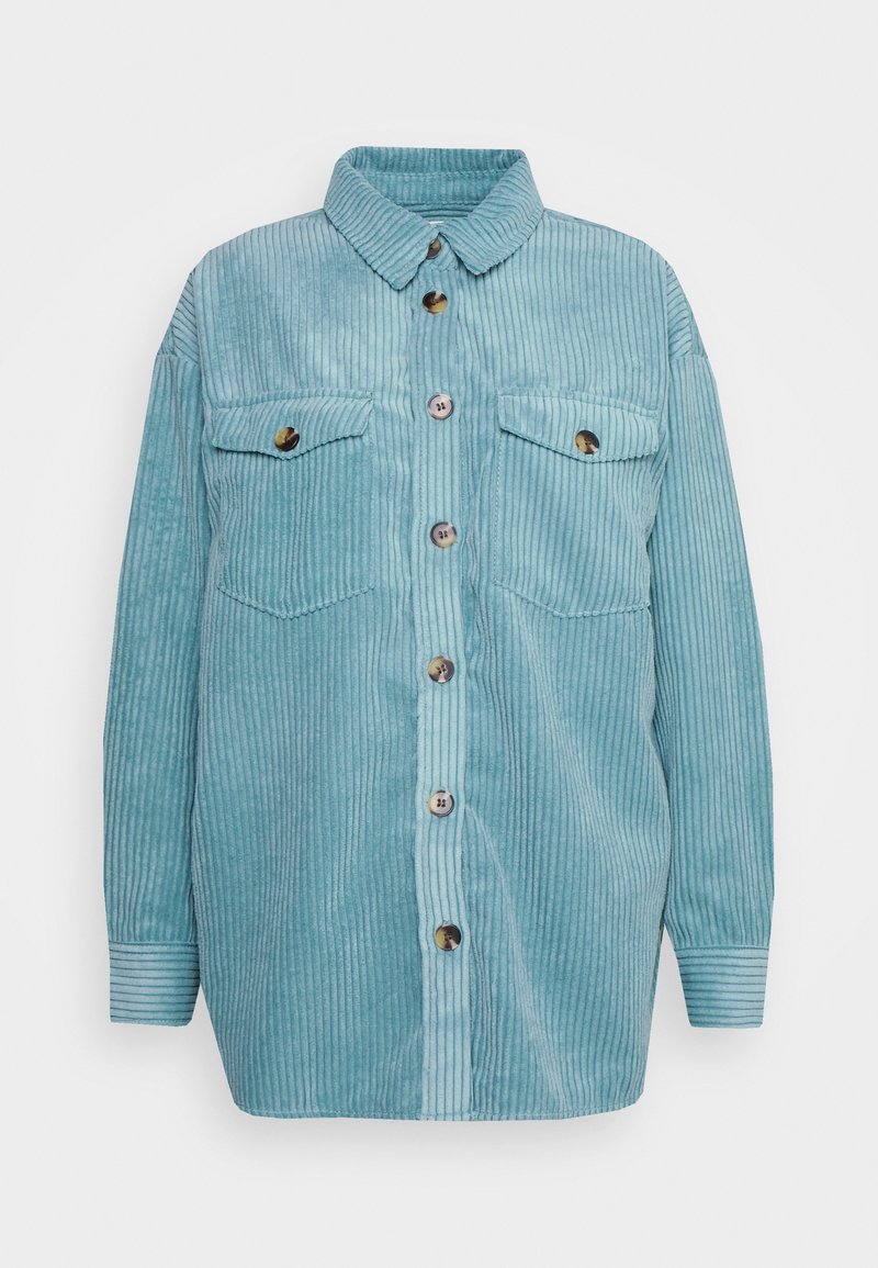 Veste-chemise en velours côtelé bleu clair, manches longues, boutonnée sur le devant, deux poches poitrine à rabats boutonnés et col classique.